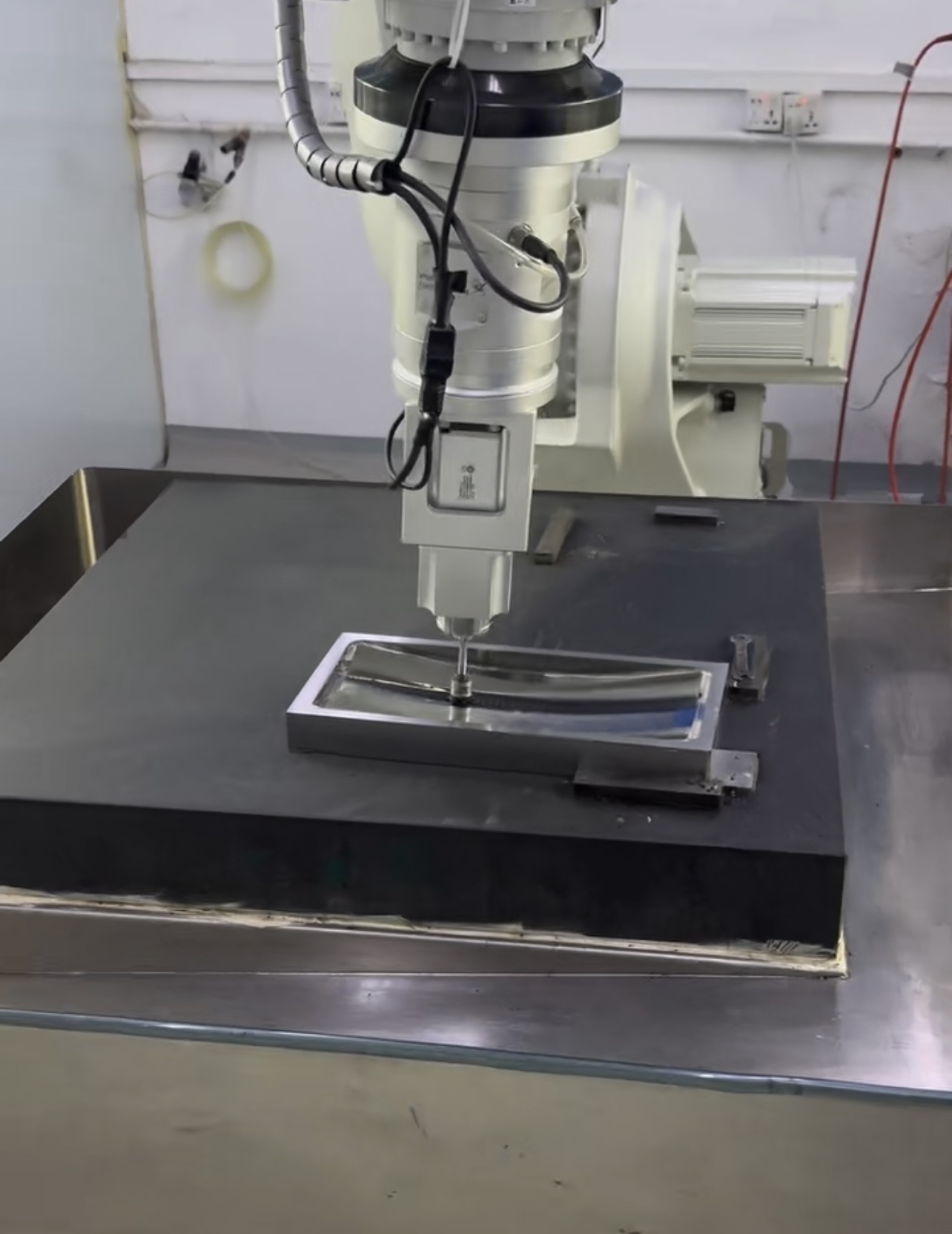 Machine head positioned against a curved tooling workpiece